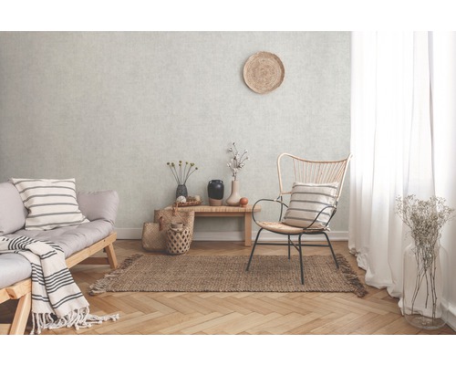 Obývací pokoj s pohovkou, židlí a kobercem na parketové podlaze před strukturovanou stěnou