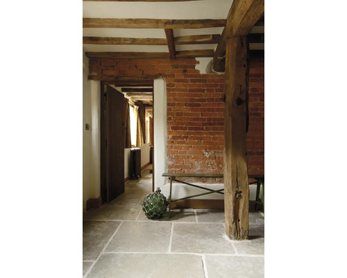 Interiér s cihlovou zdí, dřevěnými trámy a kamennou podlahou