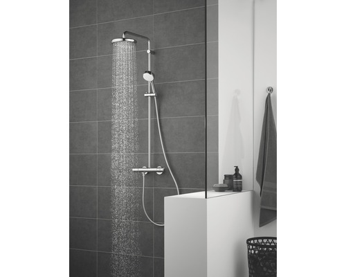 Koupelna s dešťovou sprchou, ruční sprchou a termostatickou baterií na pozadí šedých dlaždic