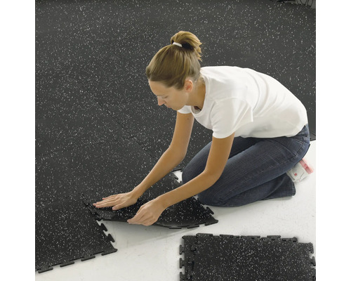 Žena pokládá kompozitní dlaždice v interiéru