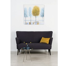 Obývací pokoj s tmavě modrou pohovkou, konferenčním stolkem s květinami a zarámovaným obrazem na stěně