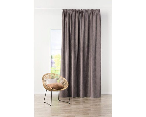 Dekorativní šály před oknem s ratanovým křeslem v místnosti