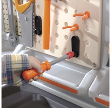 Detailní pohled na dětskou pracovní lavici s nářadím, jako je kladivo, šroubovák a pila