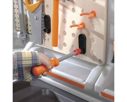 Detailní pohled na dětskou pracovní lavici s nářadím, jako je kladivo, šroubovák a pila