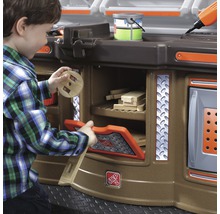 Chlapec si hraje s dětskou pracovní lavicí s úložným prostorem