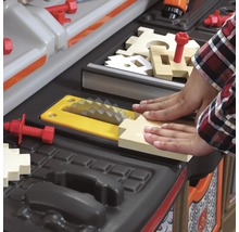 Detail dětské pracovní lavice s dřevěnými prvky a nářadím