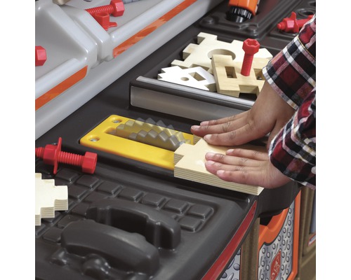 Detail dětské pracovní lavice s dřevěnými prvky a nářadím