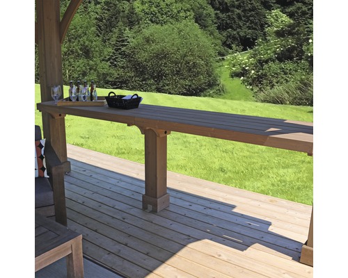 Dřevěná terasa s barovým stolem, sklenicemi a nápoji v pozadí