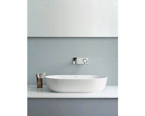 Volně stojící vana s vodovodní baterií a kelímkem na zubní kartáčky v koupelně