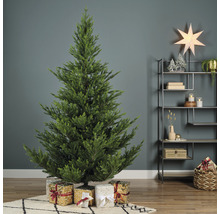 Zdobený umělý vánoční stromeček s dárky v obývacím pokoji.