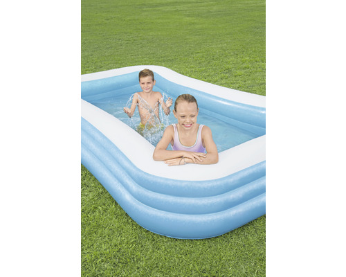Nafukovací bazén s hrajícími si dětmi na zahradě.