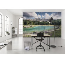 Světlá místnost s fototapetou zobrazující jezero a hory, stůl a židle