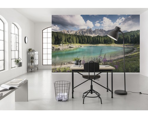 Světlá místnost s fototapetou zobrazující jezero a hory, stůl a židle