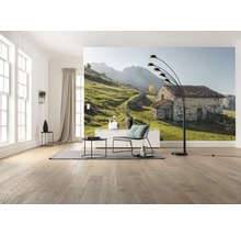 Obývací pokoj s fototapetou kamenného domu v zelené kopcovité krajině