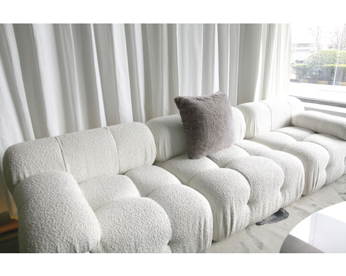 Světlý obývací pokoj s velkou modulární pohovkou a polštářem