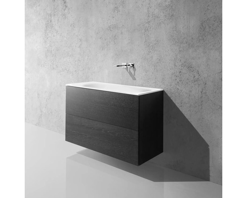 Skříňka pod umyvadlo se dvěma zásuvkami a umyvadlem na desku před betonovou stěnou