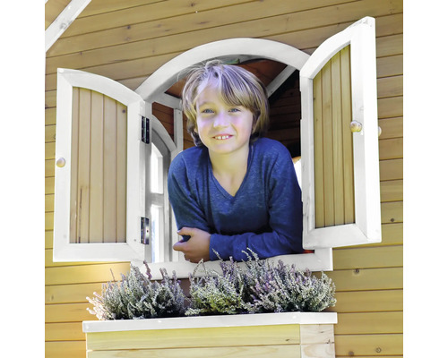 Chlapec se dívá z okna dřevěného domečku na hraní