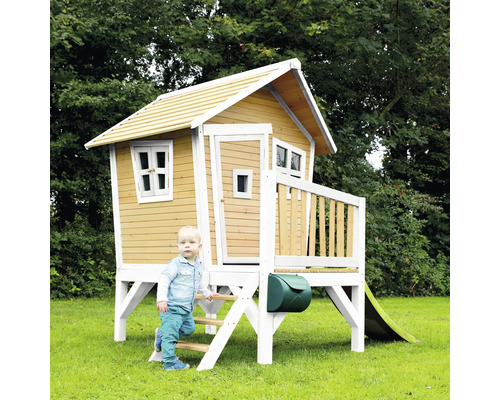 Dřevěný hrací domek se skluzavkou, žebříkem a poštovní schránkou na zahradě