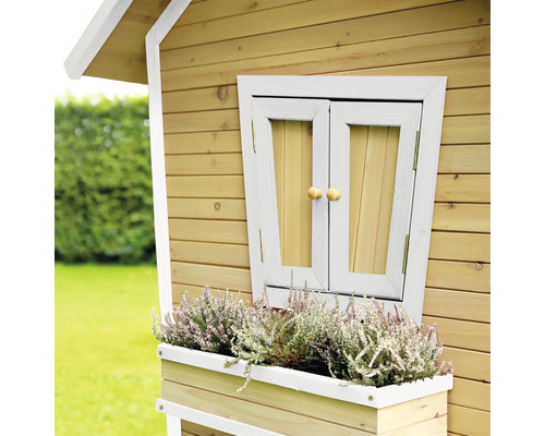 Detailní pohled na dřevěný hrací domek s oknem a truhlíkem