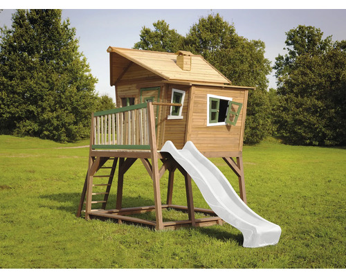 Dřevěný hrací domek se skluzavkou na zahradě.