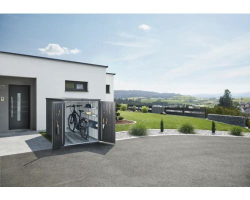 Kovová bedna na kolo s otevřenými dveřmi vedle moderního domu