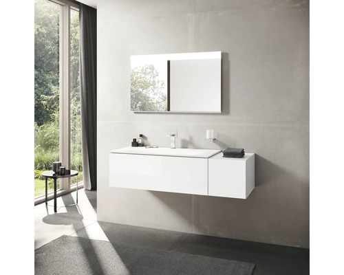 Koupelna s bílým umyvadlem, zrcadlem a baterií před velkým oknem.