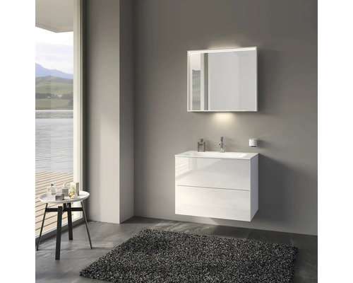 Moderní koupelna s bílou umyvadlovou skříňkou, osvětleným zrcadlem a kobercem