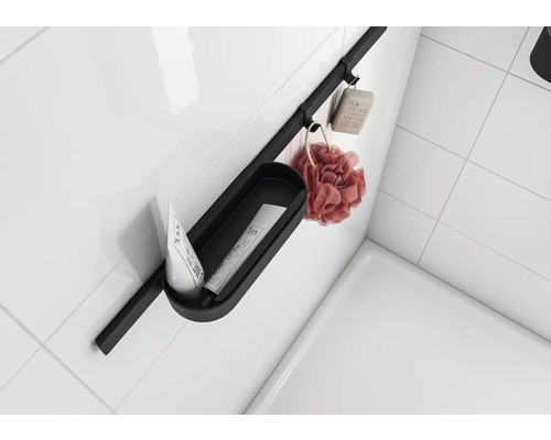 Koupelnový úložný systém s mýdlem, koupelovou houbou a kosmetickými produkty na bílé stěně.