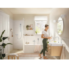 Světlá koupelna s vanou, sprchou, umyvadlem a zrcadlem v příjemném designu.