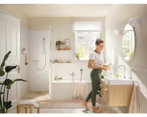 Světlá koupelna s vanou, sprchou, umyvadlem a zrcadlem v příjemném designu.