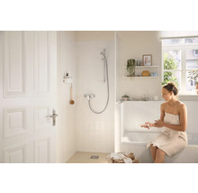 Světlá koupelna se sprchou, vanou a ženou s ručníkem