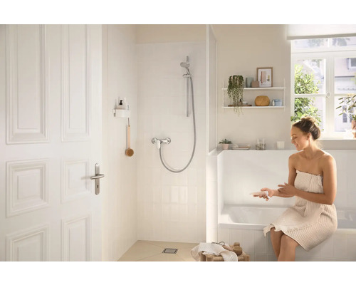 Světlá koupelna se sprchou, vanou a ženou s ručníkem