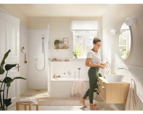 Světlá koupelna se sprchou, vanou, umyvadlem a ženou