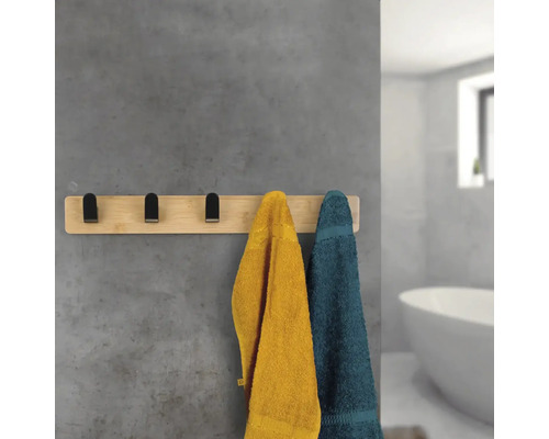 Bambusový držák na ručníky s několika ručníky v koupelně