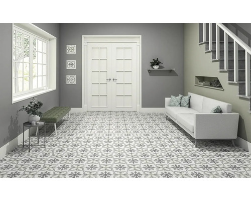 Světlá místnost se vzorovanými dlaždicemi, lavicí, pohovkou a schodištěm