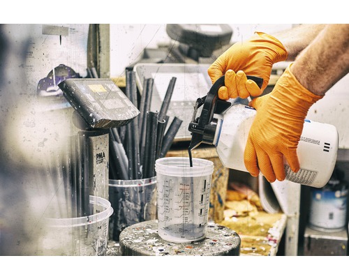 Osoba v rukavicích nalévá barvu do odměrky.