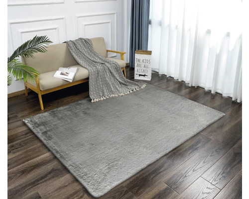 Obývací pokoj se šedým kobercem, pohovkou a závěsy