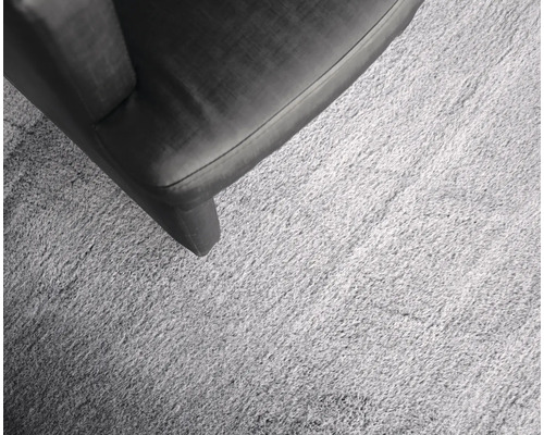 Detail světlého koberce vedle kusu nábytku