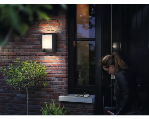 Exteriér s osvětlenými nástěnnými svítidly vedle vchodových dveří