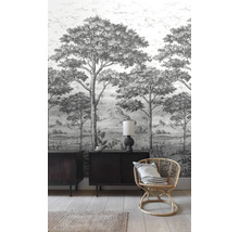 Pohled na místnost s tapetou se vzorem, komodou a ratanovým křeslem