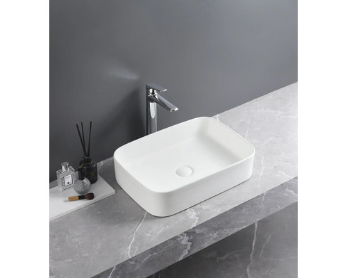 Obdélníkové keramické umyvadlo s vodovodní baterií na mramorové desce