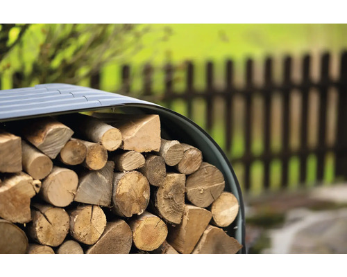 Hromada dřeva pod přístřeškem pro uskladnění dřeva na zahradě