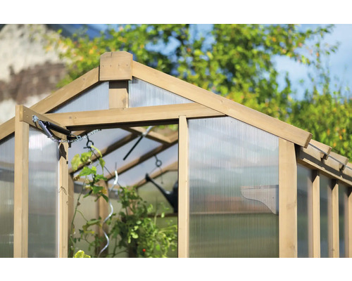 Detailní pohled na skleník s dřevěným rámem a transparentním obložením.