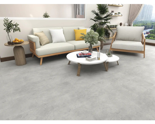 Obývací pokoj s pohovkou, křeslem a konferenčními stolky na šedé podlaze.