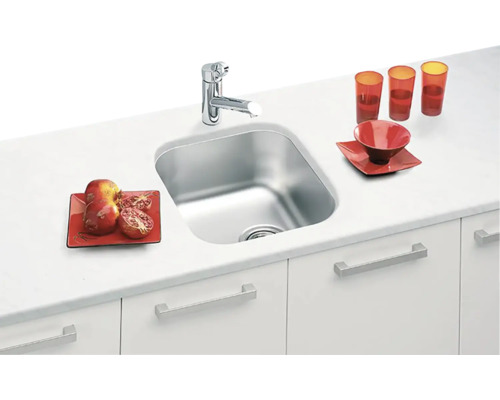 Nerezový kuchyňský dřez s vodovodní baterií na kuchyňské lince s nádobím