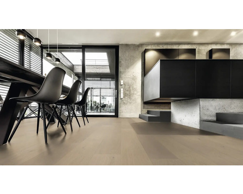 Světlá obývací místnost s dřevěnou podlahou, jídelním stolem a černými židlemi.