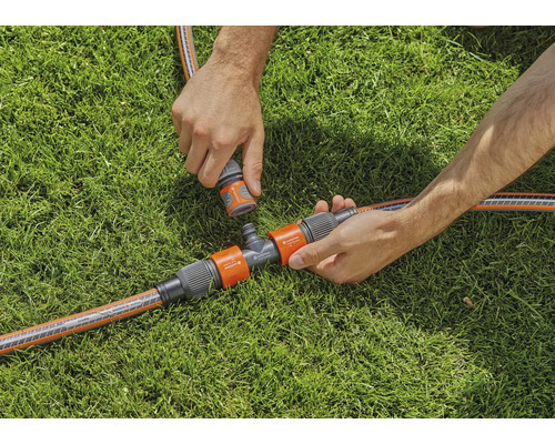 Scéna zavlažování zahrady s T-kusem a hadicovými spojkami na trávníku