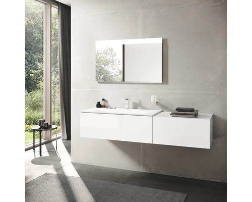 Světlá koupelna s umyvadlem, zrcadlem a oknem.