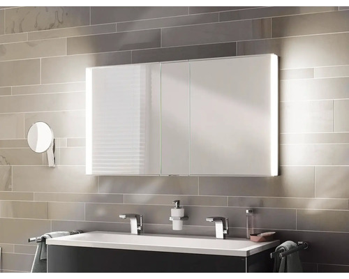 Moderní koupelna s osvětlenou zrcadlovou skříňkou, umyvadlem a doplňky