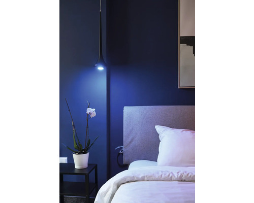 Ložnice s postelí, nočním stolkem, orchidejí a závěsnou lampou